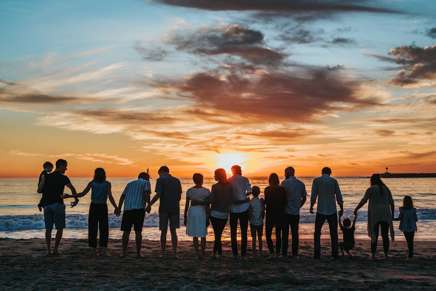 Grupo reunido na praia ao pôr do sol