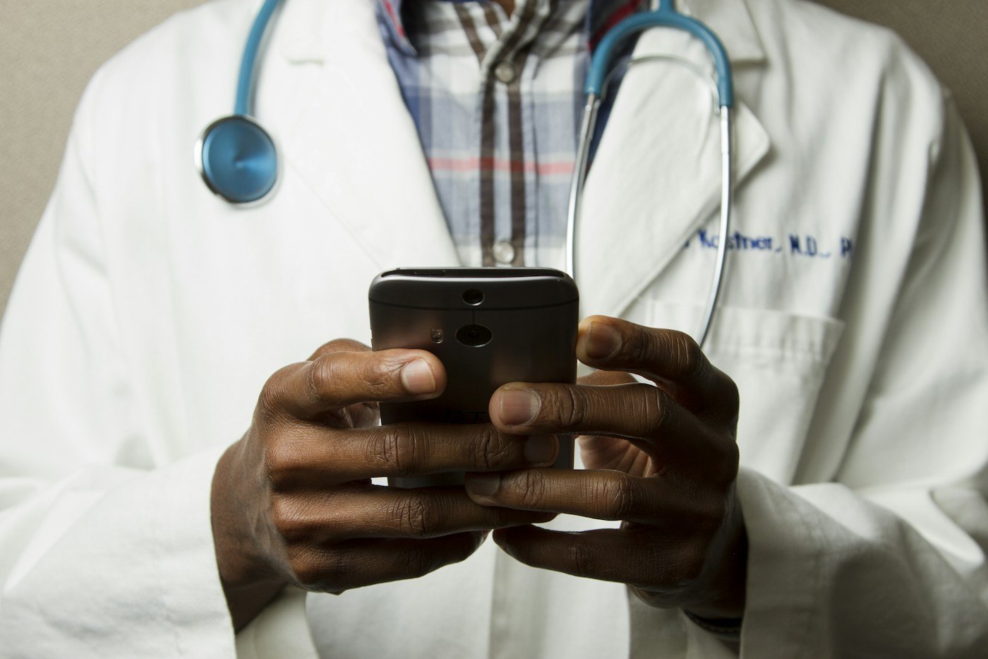 Profissional de saúde com estetoscópio e celular